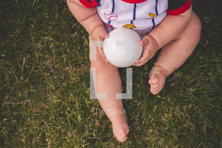 infant boy holding a baseball 