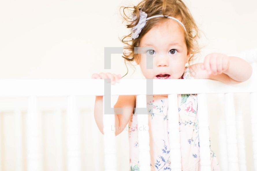a toddler girl in a crib 