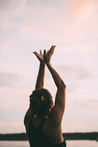 woman with hands raised into the sky 