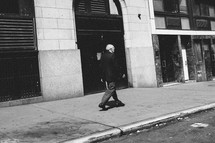 an elderly man walking down a city sidewalk 