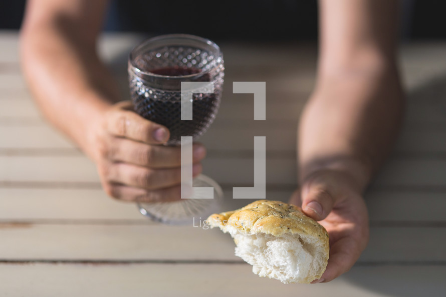 man holding communion bread and wine 