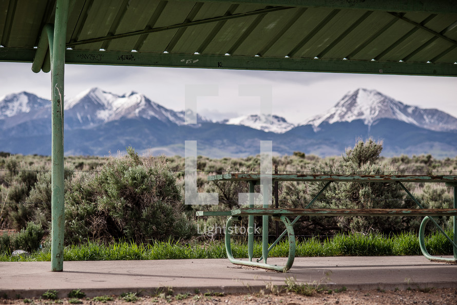 picnic table under a cover and view of mountains 