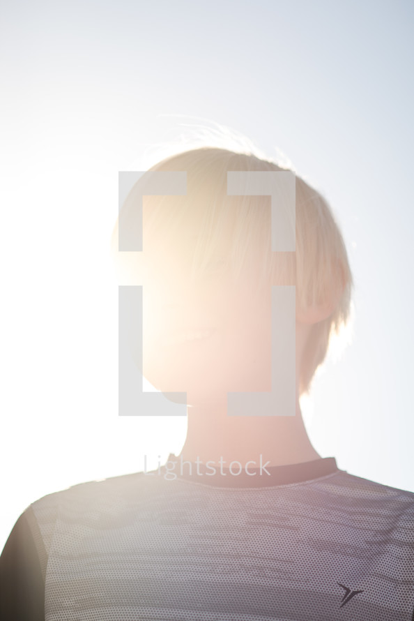 a boy child standing in the sunlight 