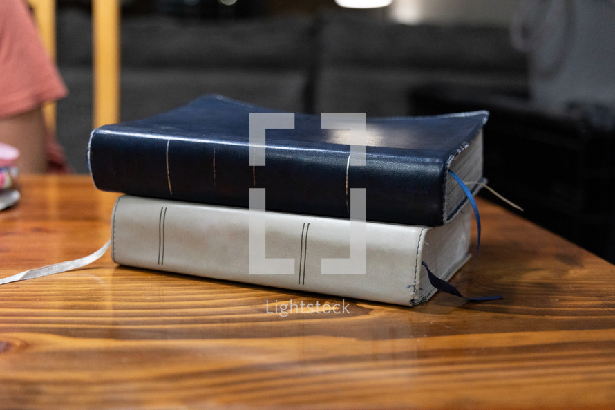 Stack of two Bibles on wooden table during Bible study