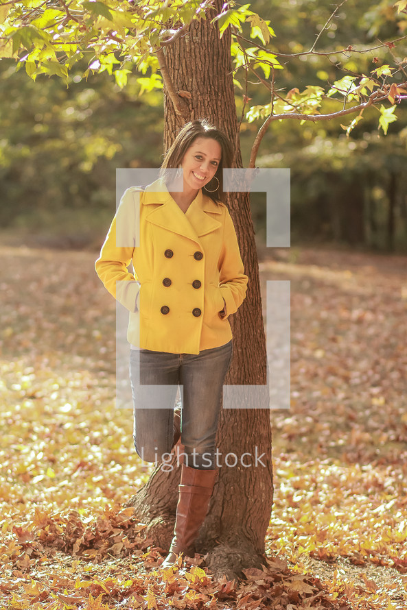 smiling young woman standing outdoors in fall 