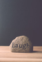 a rock with the word laugh 