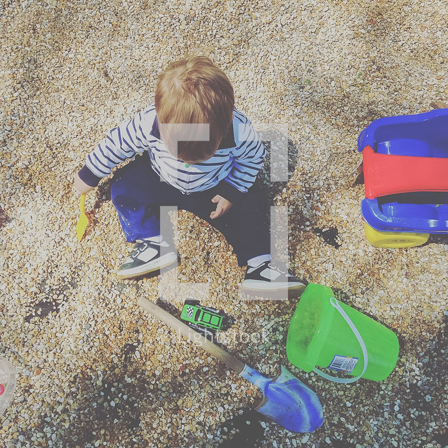 a child playing in gravel 