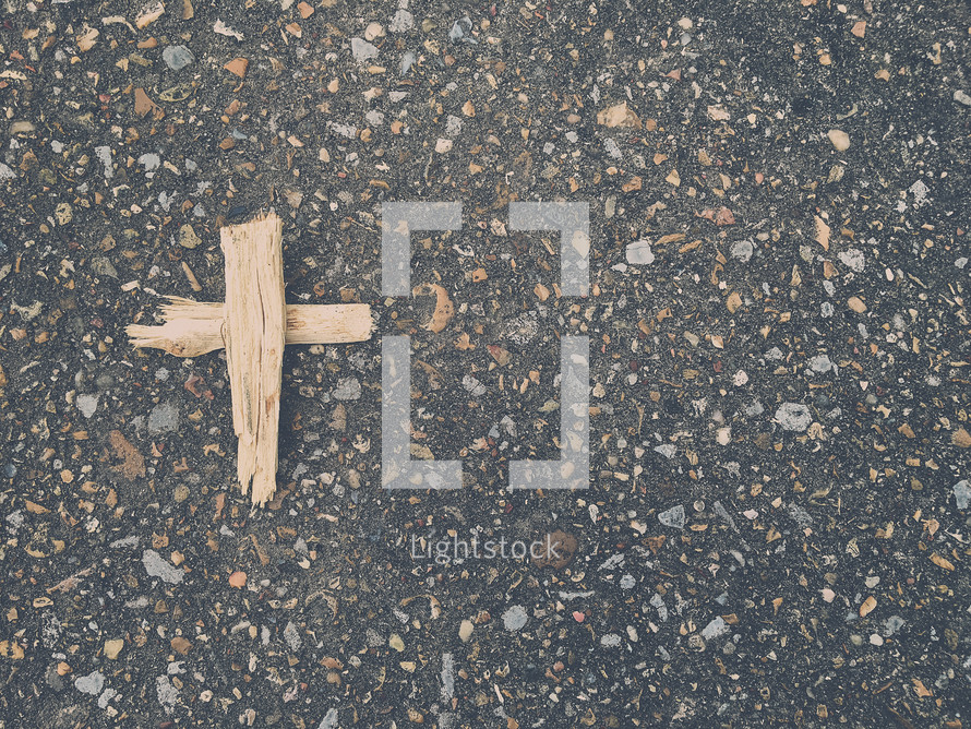wooden cross on asphalt 