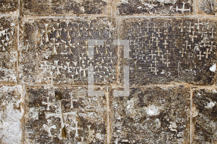 Crosses etched into the stone wall inside of the Church of the Holy Sepulchre.