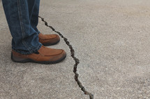 man standing beside a crack 