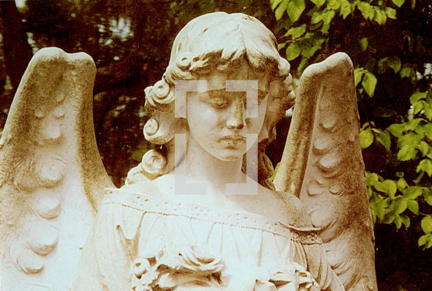A statue of a guardian angel at a historic grave site looking pensive and thoughtful guarding and standing over a grave. How sober a thought to think about eternity and eternal life when visiting a grave yard or cemetery thinking about loved ones that have gone on before us and hoping to see again one day for all eternity in Heaven with Christ Jesus and the Angelic Heavenly host. 