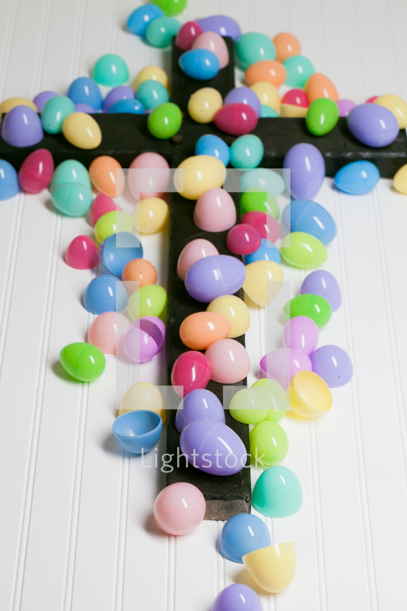 Colorful plastic Easter eggs in top of a cross.