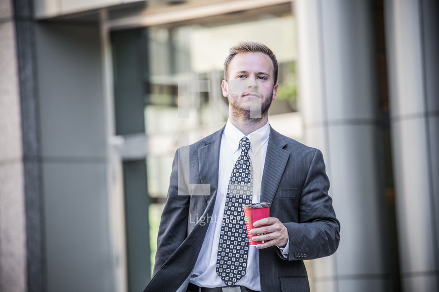 businessman walking with a coffee cup 