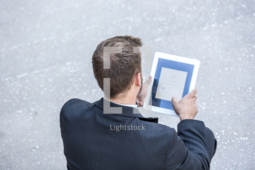 businessman looking at an iPad screen 