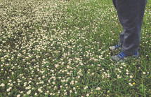 a child standing in a field of clover flowers