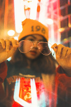 a girl holding up glasses 