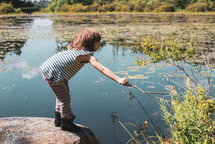 a girl playing near a pond 