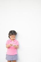 a toddler girl looking at a cellphone screen 