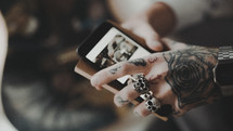 tattooed hand holding a cellphone 