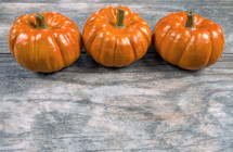 three pumpkins on a wood background 