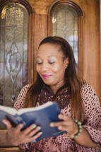 African American woman reading from a Bible 