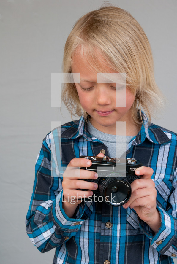 a boy child holding a camera 