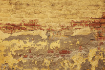 Eroded, plastered, painted brick wall