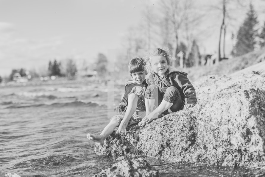 children sitting along a shore 
