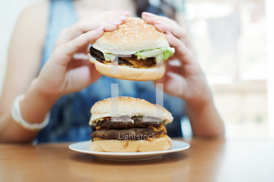 a woman eating a hamburger 