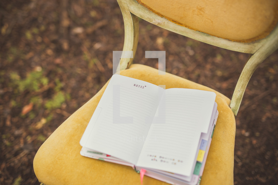 journal on a chair in a forest 