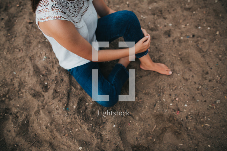a woman sitting in sand 