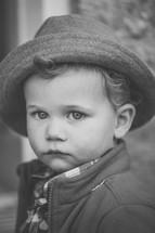 A little boy in a coat and hat.