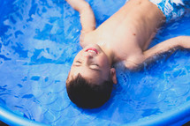 a boy child in a plastic pool 
