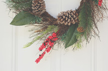 A Christmas wreath hanging on a door 