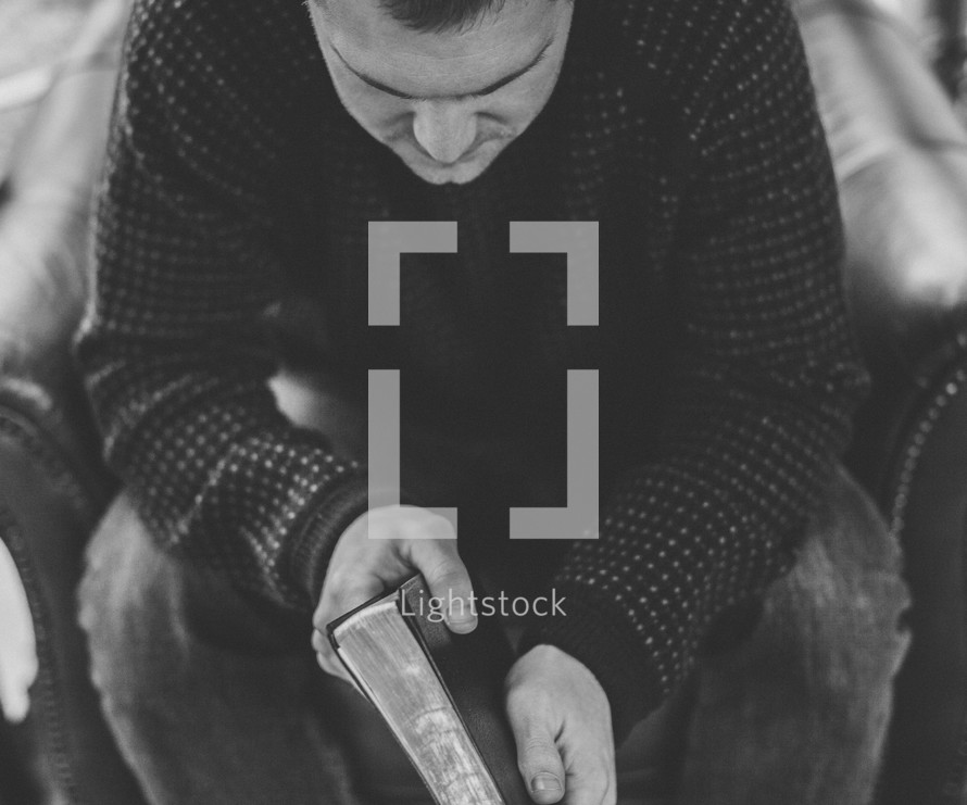 A man sitting holding a Bible 