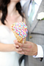 bride and groom holding an ice cream cone 