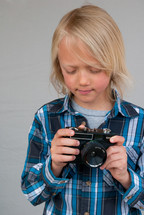 a boy child holding a camera 