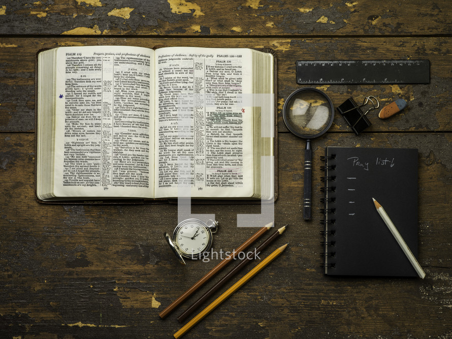 open Bible, pocket watch, pencils, and sketchbook 