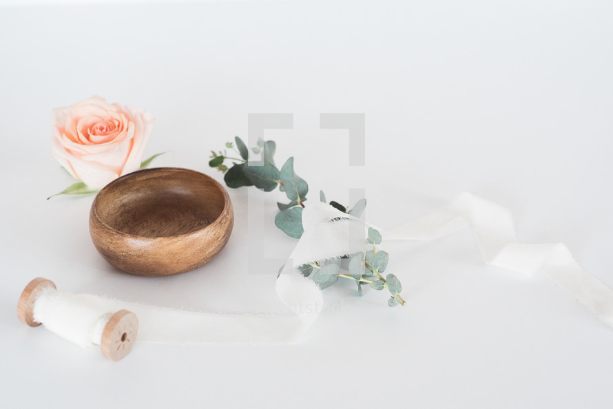 spool of ribbon, wooden bowl, with eucalyptus and roses 