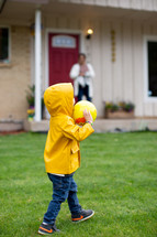 Child playing with a ball in front yard 