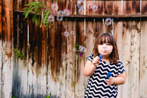 girl child blowing bubbles outdoors 