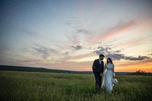 bride and groom in a field 