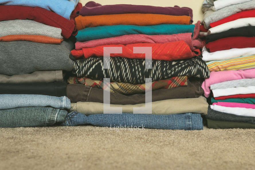 Stacks of folded clothes on the floor