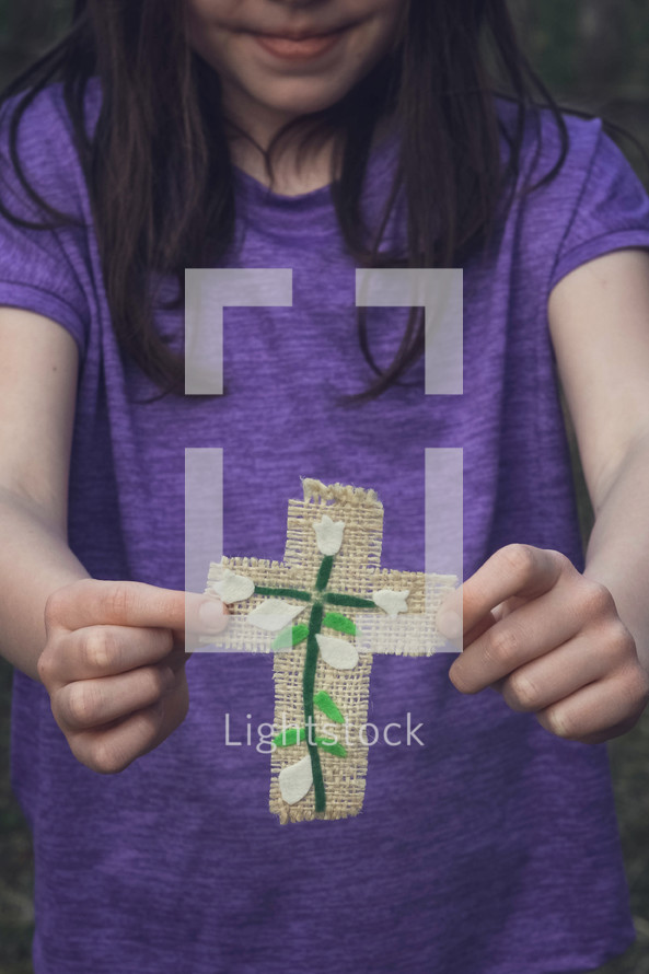 child holding a handmade cross
