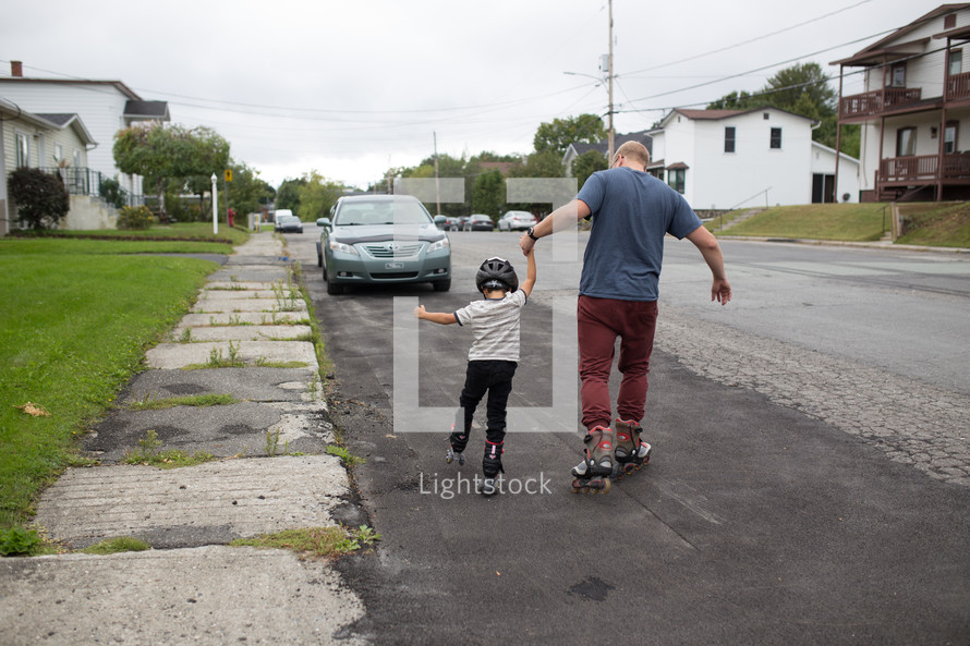 a father teaching his son to rollerblade 