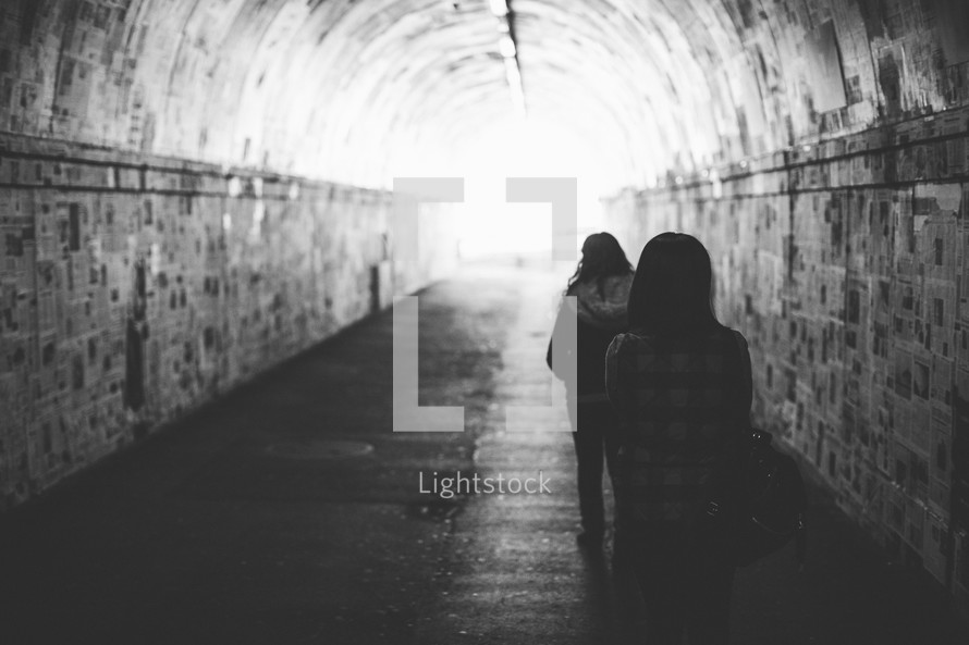women walking through a tunnel 