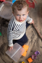 toddler boy playing in sand