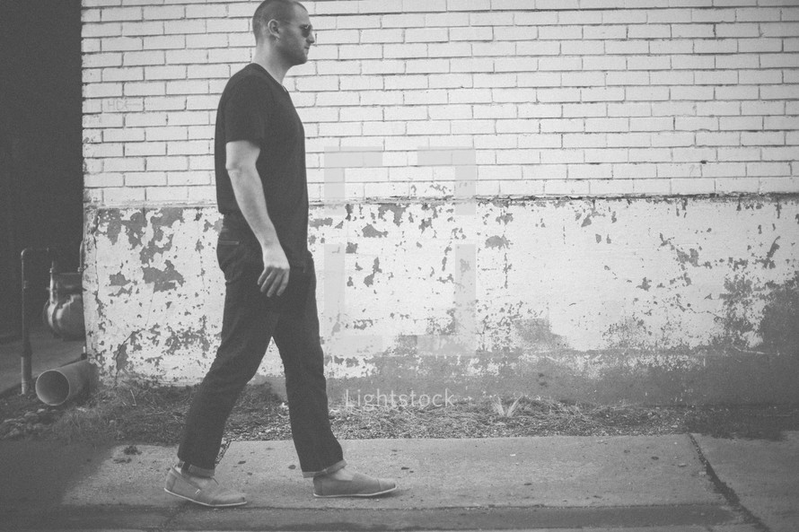 a man walking down a sidewalk 