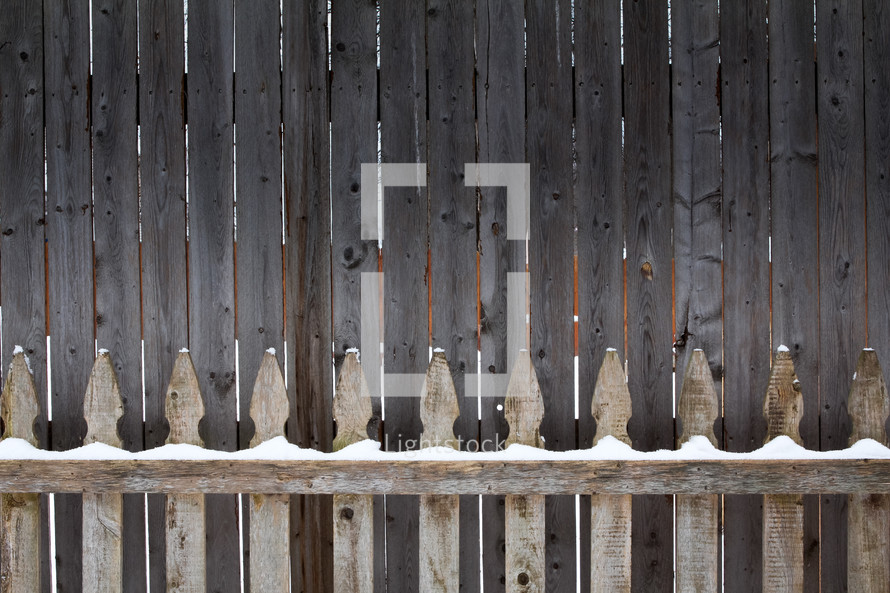 snow on a wooden fence 