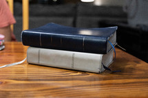 Stack of two Bibles on wooden table during Bible study